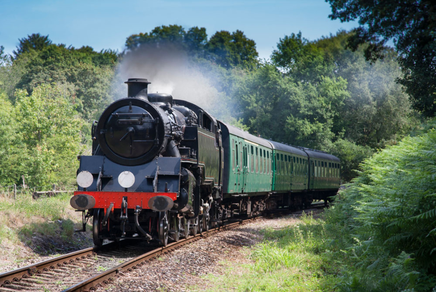 Black steam train running along the tracks