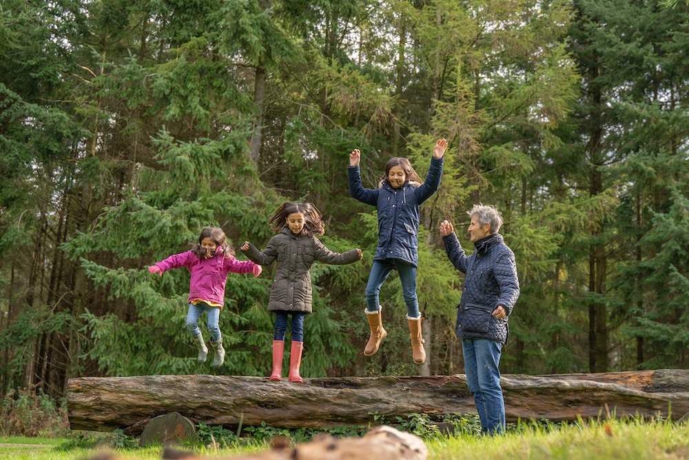 bedgebury-pinetum Family jumping off a log
