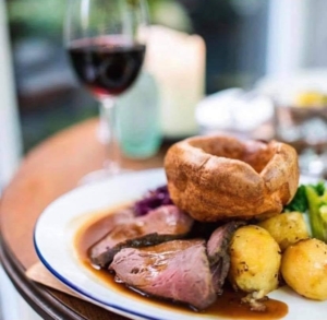 A Sunday roast beef with a glass of red wine