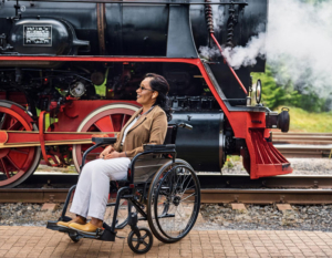 a wheelchair user in front of a steam train