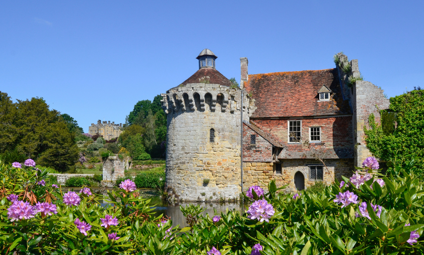 Medieval castle on a lake surrounded by flowers