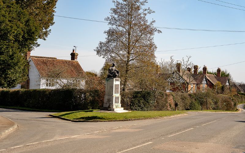 War memorial on small green next to a road